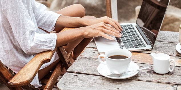 Kvinde sidder på cafe med computer