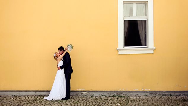 Nygift par foran gul væg