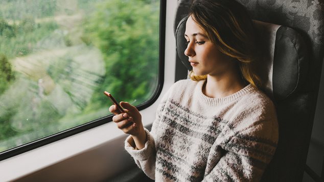 Kvinde med mobil i toget