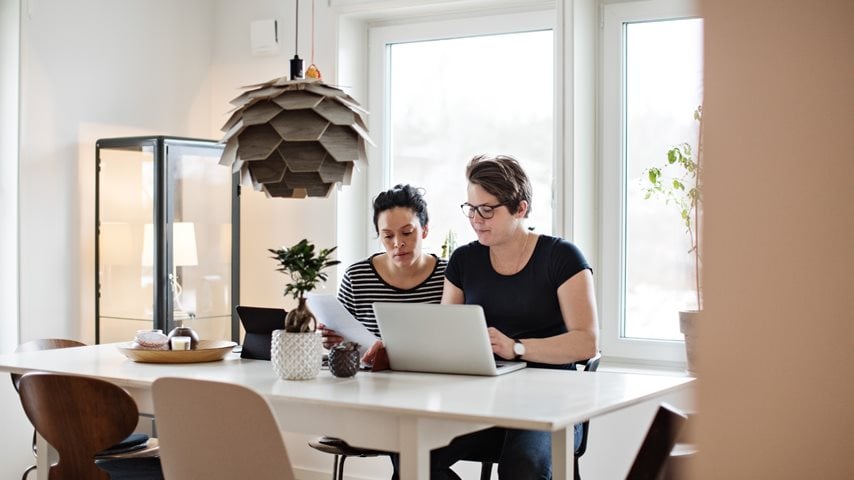 To kvinder sidder og kigger på computer